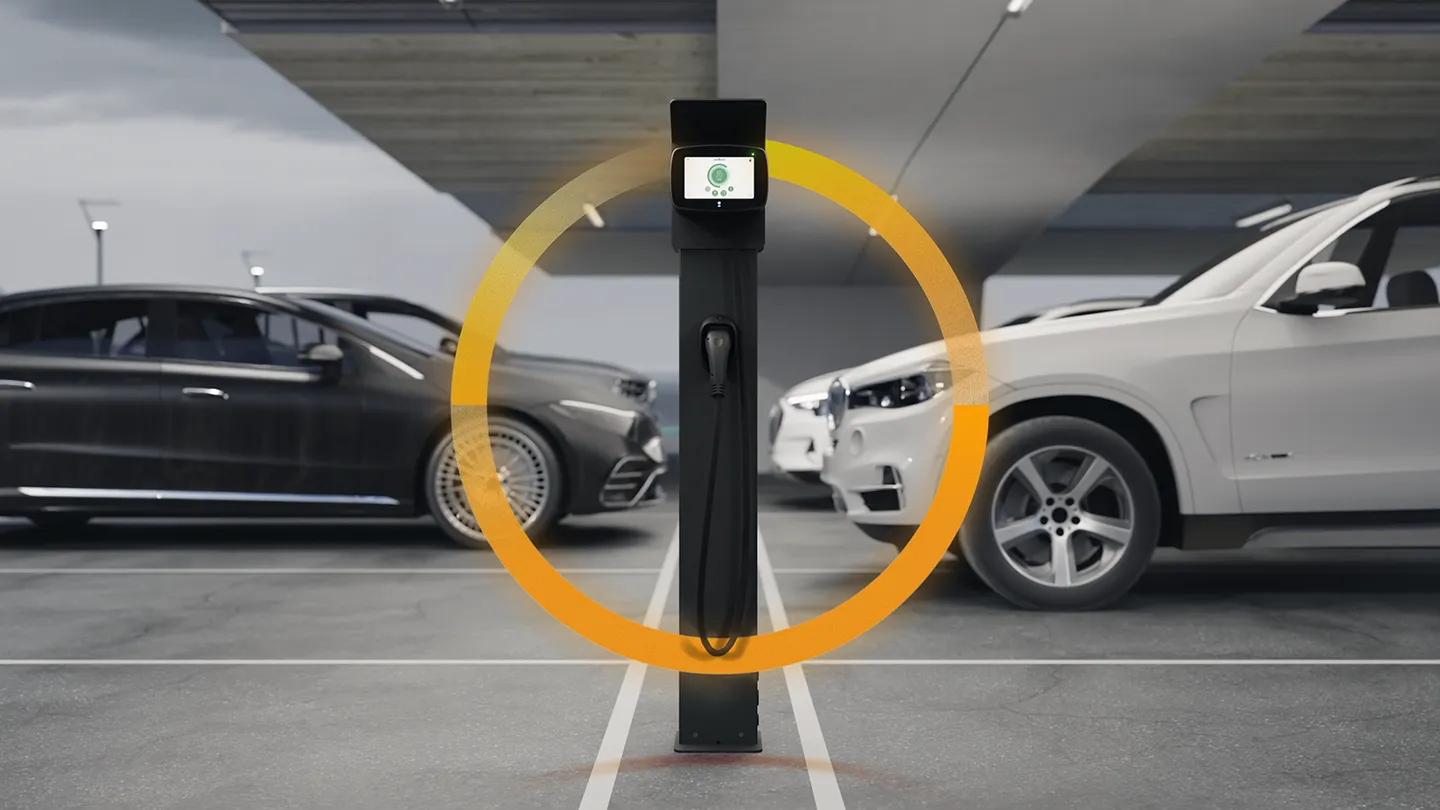 Bornes de Recharge pour véhicules électriques sur un parking entourées de voitures en arrière plan